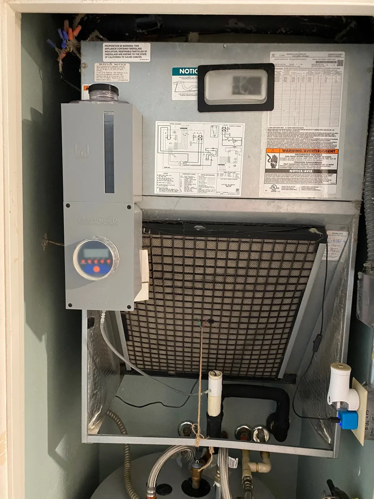 A Conde-CLEAN unit installed beside a residential air handler, with its tube running into the condensate line